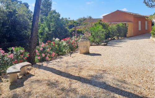 un jardin avec un banc et des fleurs, ainsi qu'une maison dans l'établissement Les Villas Au Palmier, à Cannes-et-Clairan