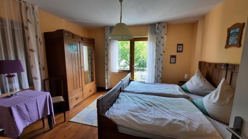 Un dormitorio con dos camas y una mesa y una ventana. en Ferienwohnung Maria Magdalena, en Bad Neuenahr-Ahrweiler
