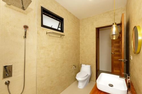 a bathroom with a toilet and a sink and a tv at 2br Seaview pool villa B in Hinkong