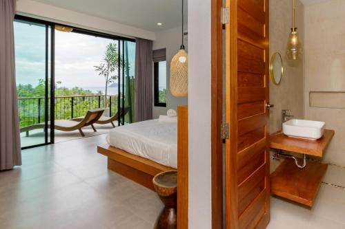 a bedroom with a bed and a bathroom with a balcony at 2br Seaview pool villa B in Hinkong