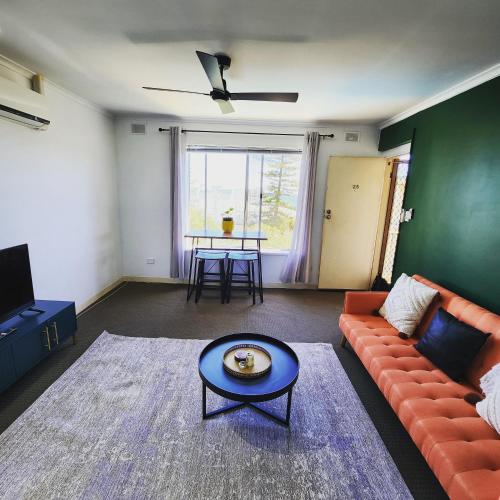 a living room with a couch and a table at Casa Luna Beachside Apartment in Henley Beach
