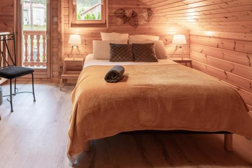 sypialnia z łóżkiem z kotem w obiekcie Chalet La Calougeotte, jardin, spa et sauna privés w mieście Le Ménil