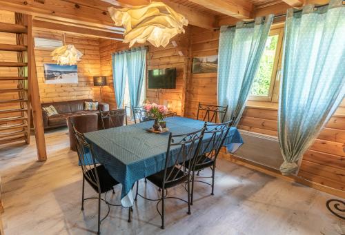 une salle à manger avec une table et des chaises bleues dans l'établissement Chalet La Calougeotte, jardin, spa et sauna privés, à Le Ménil