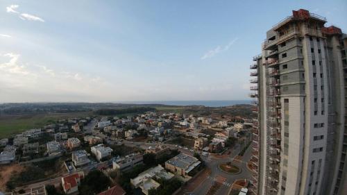 an overhead view of a city with a tall building at דירה מעוצבת עם נוף מדהים לים in H̱adera