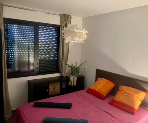 - une chambre avec un lit doté d'oreillers orange et rouge dans l'établissement Toit terrasse les Embiez, à Six-Fours-les-Plages