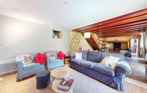 un salon avec deux canapés bleus et une table dans l'établissement Lovely Home In Salignac-Eyvigues, à Salignac Eyvigues
