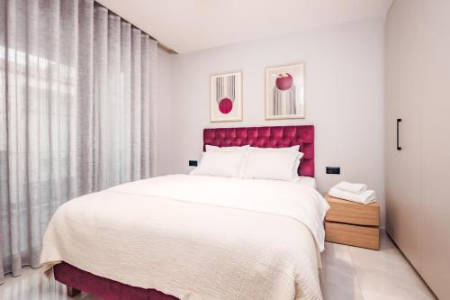 a bedroom with a large bed with a red headboard at Urban Apartments in Chios