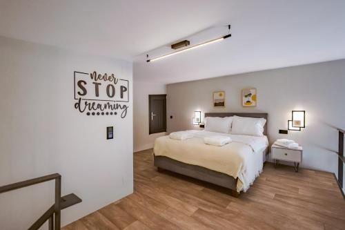 a bedroom with a bed and a sign that reads stop whining at Urban Apartments in Chios