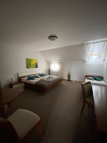 a large bedroom with a bed and a chair at Pivovarsky Hotel Kojetín u Kroměříže in Kojetín