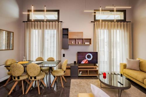 a living room with a table and chairs and a couch at Urban Apartments in Chios