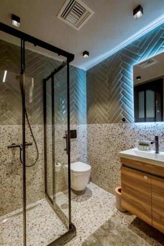 a bathroom with a shower and a toilet and a sink at Urban Apartments in Chios