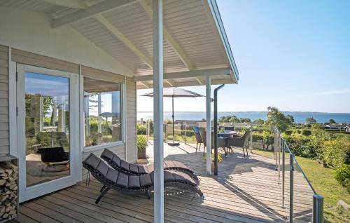 a porch of a house with a bench and an umbrella at Fyrrehuset in Helnæs By