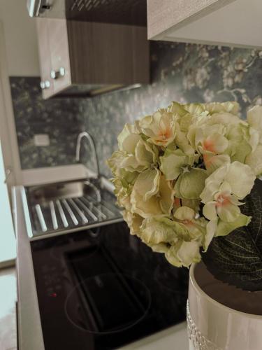 a vase with a bouquet of flowers in a kitchen at Soffio del Salento in Matino