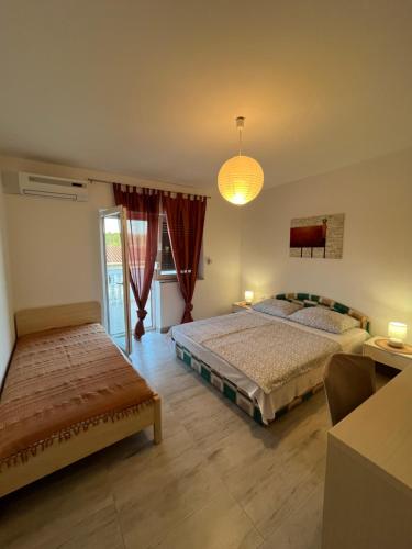 a bedroom with two beds and a chandelier at Apartments Mais Tisno in Tisno