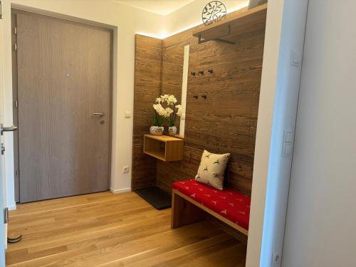 a hallway with a red bench and a wooden wall at Alpenkind in Mittenwald