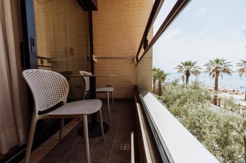 a balcony with two chairs and a view of the ocean at Royal G Hotel and Spa in Durrës