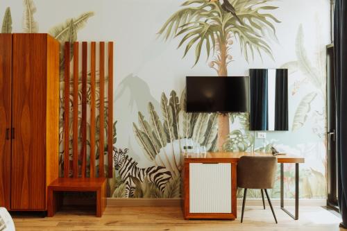 a living room with a desk and a tv on a wall at Royal G Hotel and Spa in Durrës