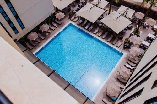 an overhead view of a swimming pool with chairs and umbrellas at Royal G Hotel and Spa in Durrës