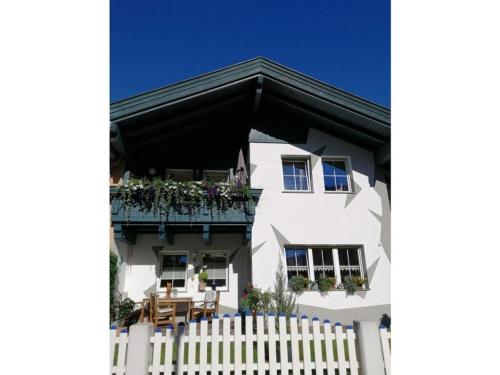 a white house with a balcony and a white picket fence at Apart Rosi Comfortable holiday residence in Aschau