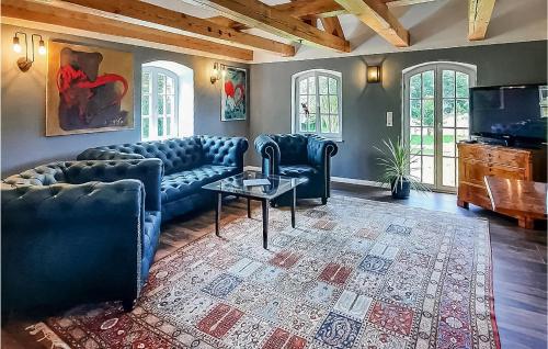 a living room with blue couches and a table at Haus Birgit C in Kuhlen