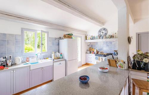 une cuisine avec des armoires blanches et un réfrigérateur blanc dans l'établissement Gorgeous Home In Callian With Wifi, à Callian