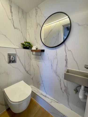a bathroom with a white toilet and a mirror at C Tower Premium Apartments, Panoramic Sea View in Netanya