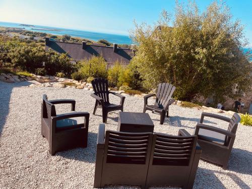 a group of chairs and a table on a gravel field at Gite proche mer in Cherbourg en Cotentin