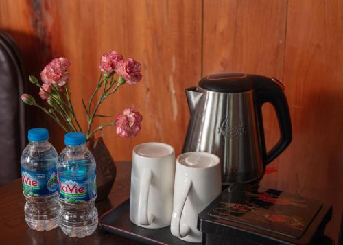 a table with a coffee pot and two bottles of water at Gateway Inn Puluong in Pu Luong