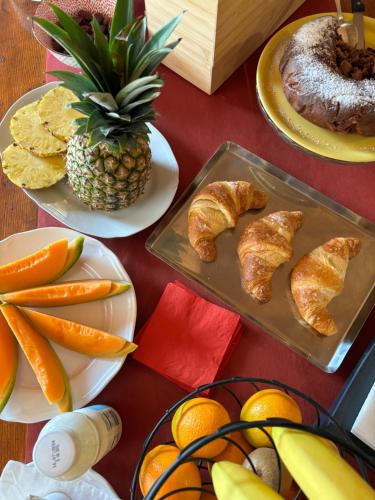 a table topped with plates of pastries and fruit at Siore Marie gli alloggi in San Giórgio di Nogaro