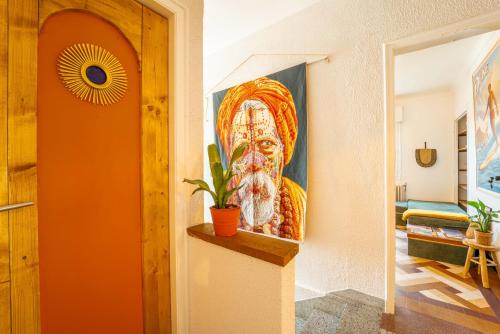 a painting of a guru on a wall in a hallway at La Boga L'Auberge à l'ambiance Surf à Biscarrosse Plage in Biscarrosse-Plage