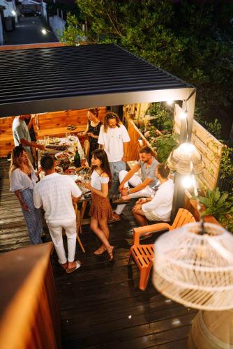 a group of people sitting around a table on a deck at La Boga L'Auberge à l'ambiance Surf à Biscarrosse Plage in Biscarrosse-Plage