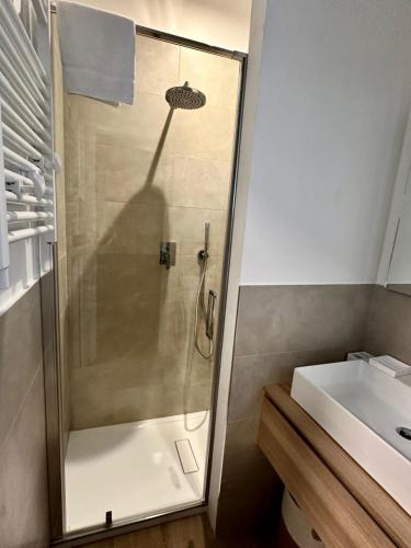 a shower with a glass door next to a sink at Appartamento Sole in Numana