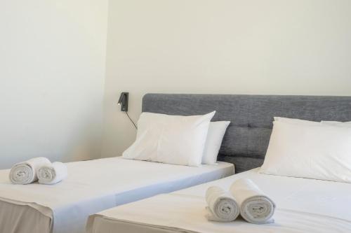 two beds in a room with towels on them at Gioma Luxury Suites - Lake View - Jacuzzi in Agios Nikolaos