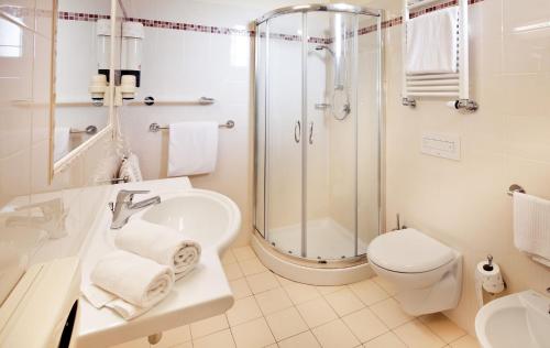 ein Bad mit einer Dusche, einem Waschbecken und einem WC in der Unterkunft Hotel Beaurivage in Fano