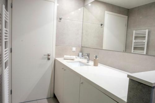 a white bathroom with a sink and a mirror at Gioma Luxury Suites - Lake View - Jacuzzi in Agios Nikolaos