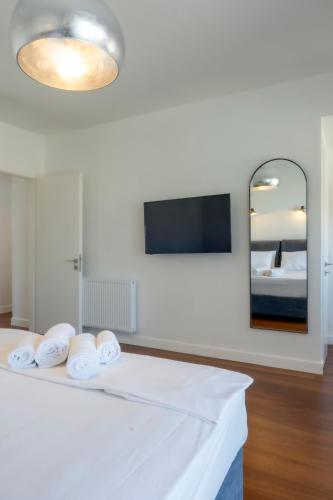 a white room with a bed and a mirror at Gioma Luxury Suites - Lake View - Jacuzzi in Agios Nikolaos