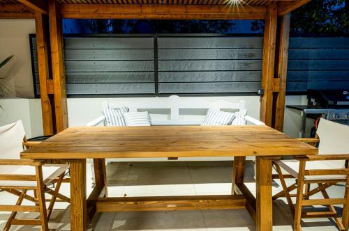 a wooden table and chairs on a patio at Gioma Luxury Suites - Lake View - Jacuzzi in Agios Nikolaos