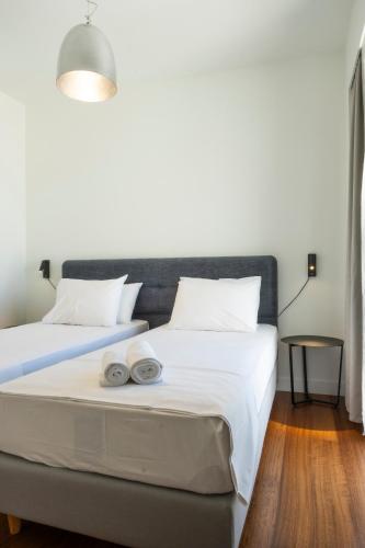 a bedroom with two beds with white sheets at Gioma Luxury Suites - Lake View - Jacuzzi in Agios Nikolaos