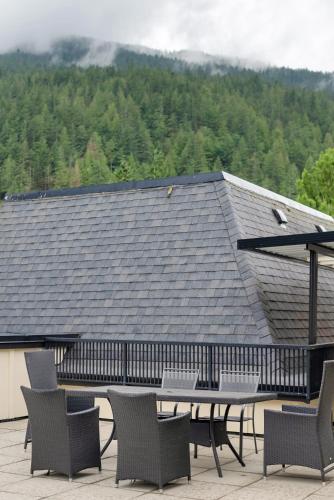 a patio with a table and chairs and a roof at Lakeview Splendor- 7BR Penthouse Bliss Combo unit in Harrison Hot Springs