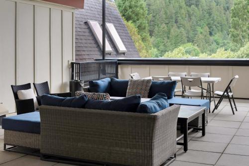 a patio with couches and tables on a balcony at Lakeview Splendor- 7BR Penthouse Bliss Combo unit in Harrison Hot Springs