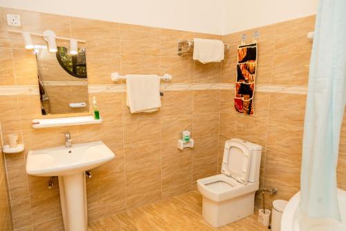 a bathroom with a toilet and a sink at High Ground Villa Ltd in Kigali