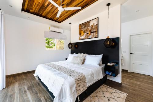 a bedroom with a large bed with a black headboard at Casa Serena - Ocean View 3 Br House in Brasilito
