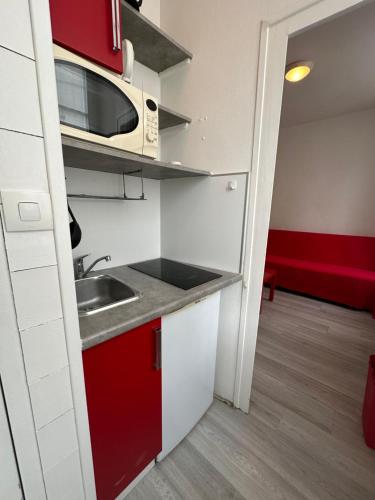 une petite cuisine avec un évier et un micro-ondes dans l'établissement Charmant Studio Carmes 3 - CDDT, à La Rochelle