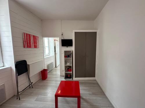 un salon avec un tabouret rouge et une porte dans l'établissement Charmant Studio Carmes 3 - CDDT, à La Rochelle
