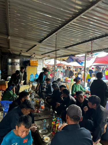 a group of people sitting at tables eating food at Epic Đồng Văn Hotel in Dồng Văn