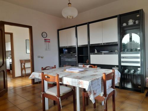 a dining room with a table and chairs and a kitchen at Appartamento da Valentino in S'archittu Cuglieri