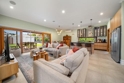 a living room with two couches and a kitchen at Stanley Stay - Sauna, Play set, WiFi, Central Location in Woodville