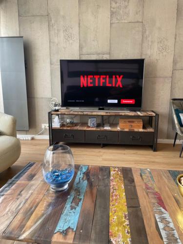 a living room with a television and a table at Appart spacieux 6 pers proche centre ville et gare Laval - Parking privé securisé in Laval
