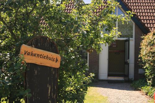 a sign on a wooden post in front of a house at Rufus aan het water in Broek