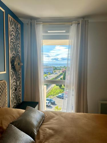 une chambre avec un lit et une fenêtre avec vue dans l'établissement Appartement neuf proche plage, à Sète